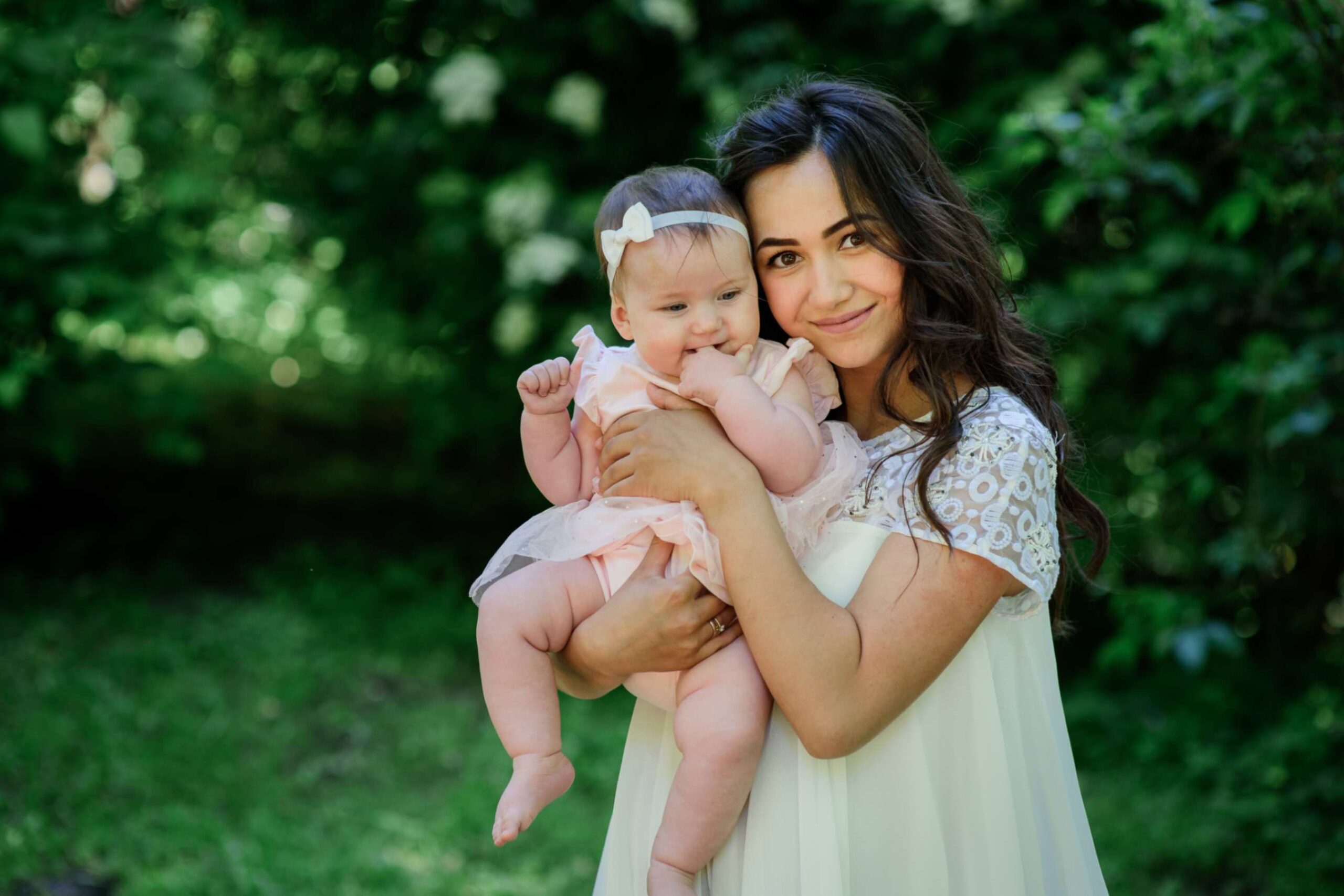 jpeg-optimizer_pretty-brunette-woman-white-dress-poses-with-her-little-daughter-garden